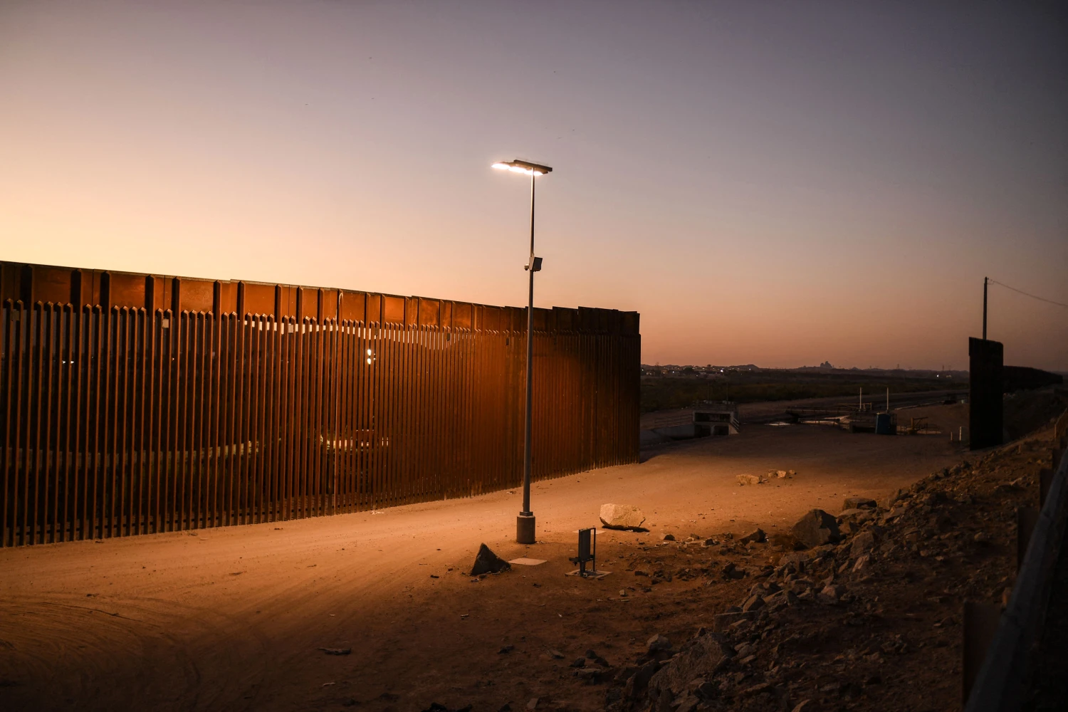 Border wall infrastructure at sunset