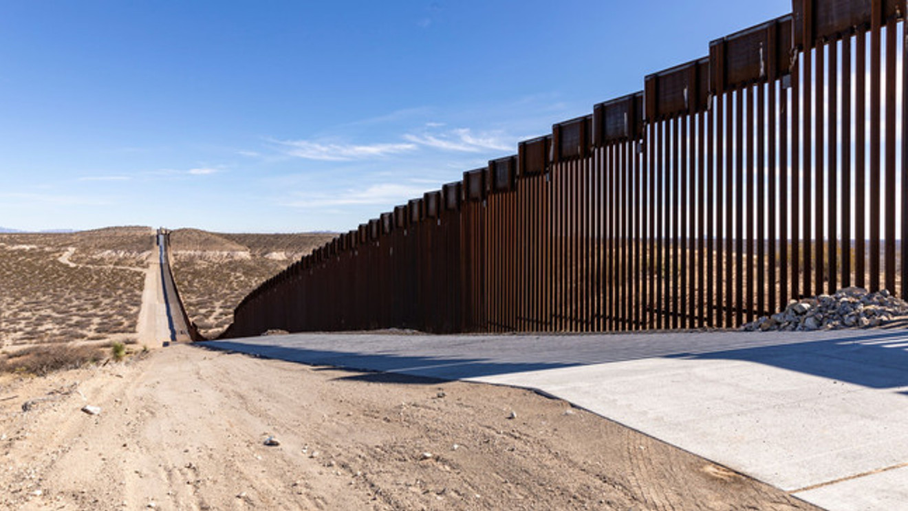 Border wall infrastructure stretching into the distance